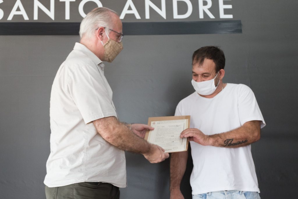 Morador Claudemir Aparecido de Godoi  recebe documentação da matrícula. Foto: Alex Cavanha/PSA